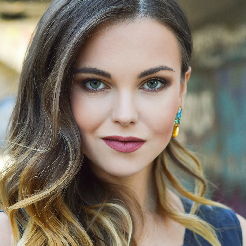 smiling dentist examining patient, warm lighting, modern dental office with beige and salmon color scheme