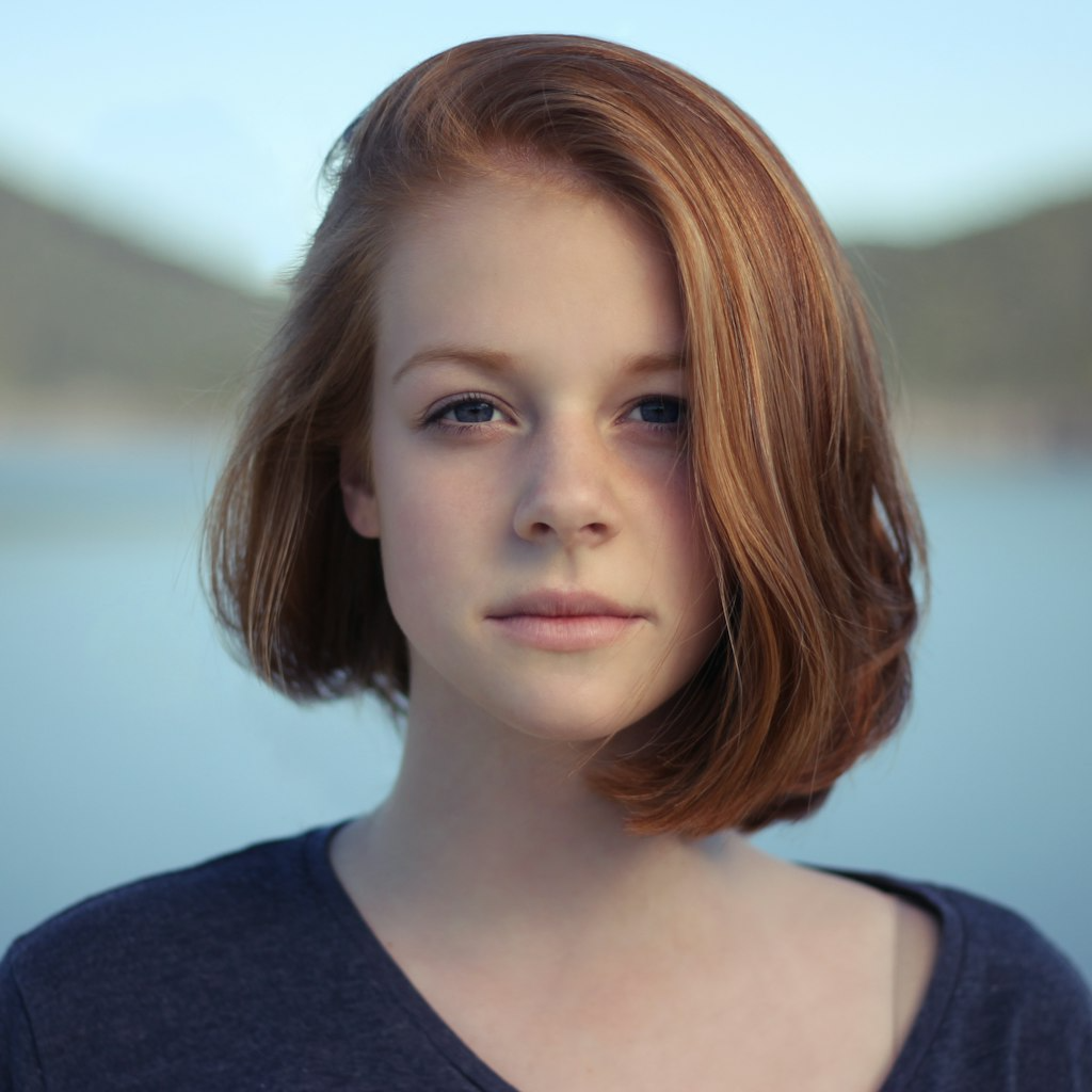 smiling dentist examining patient, warm lighting, modern dental office with beige and salmon color scheme